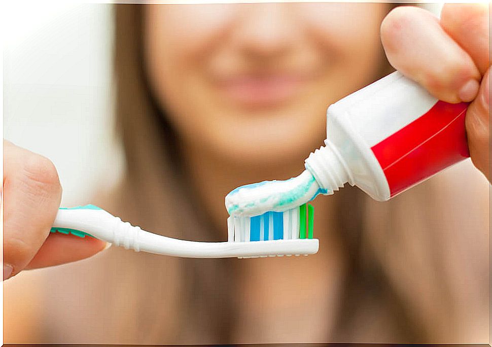 Woman pouring toothpaste on brush.