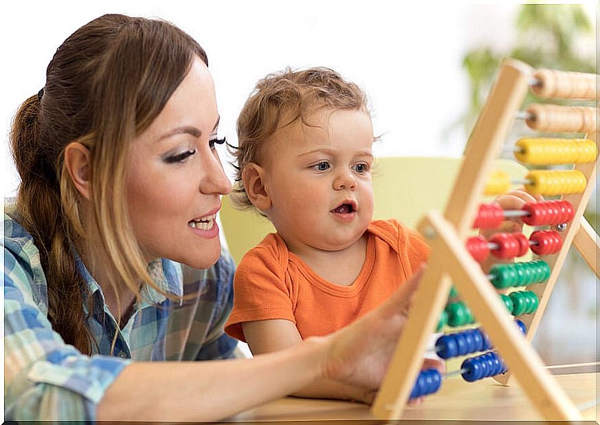 Boy and mom with abacus doing activities to teach their child to calculate.