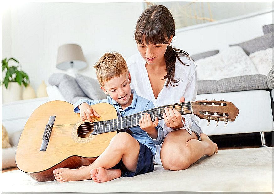 Boy plays guitar with his mother