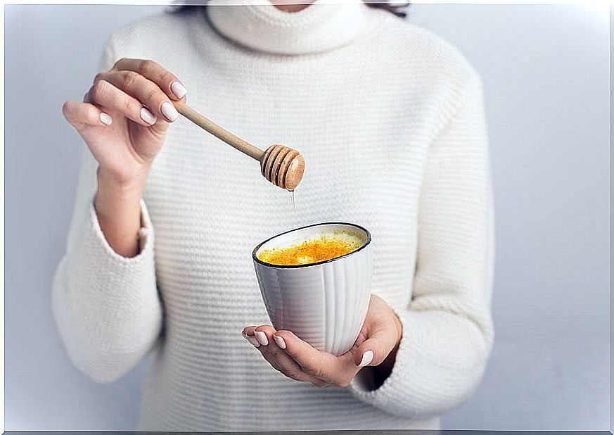 Woman holding a drink to cure a sore throat.