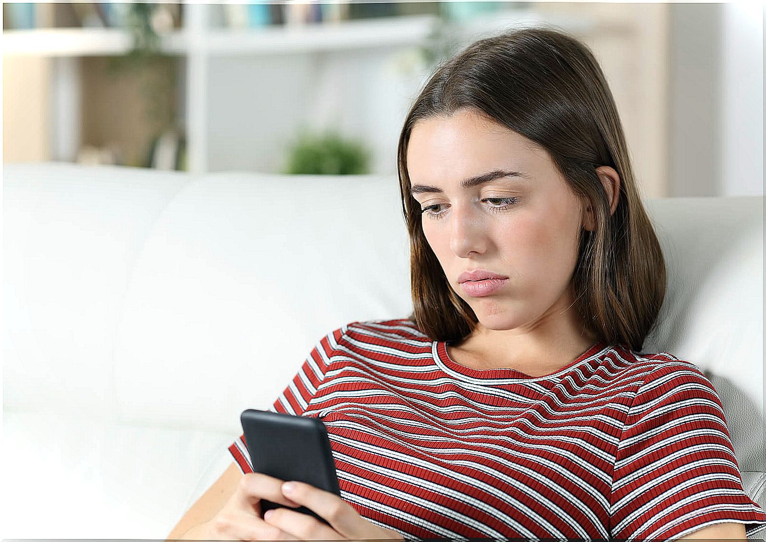 Woman checks mobile without moving.