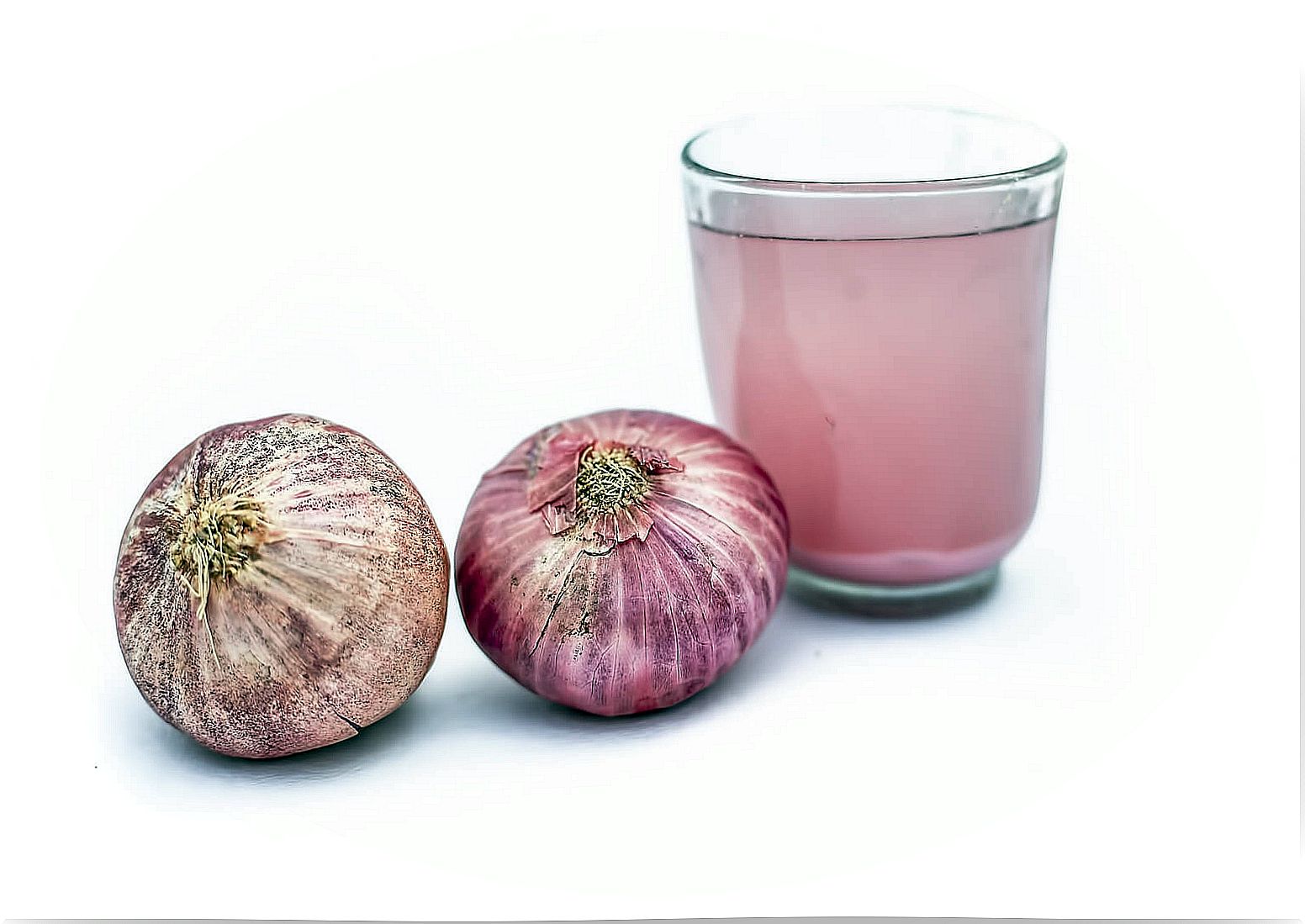 Glass with onion juice and purple garlic.