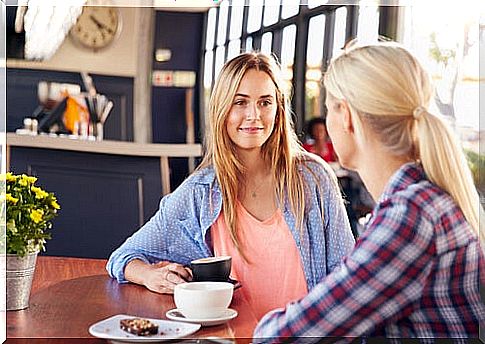 Two women talking while having coffee.