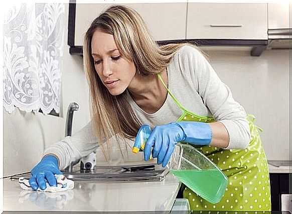 housewife cleaning furniture in kitchen