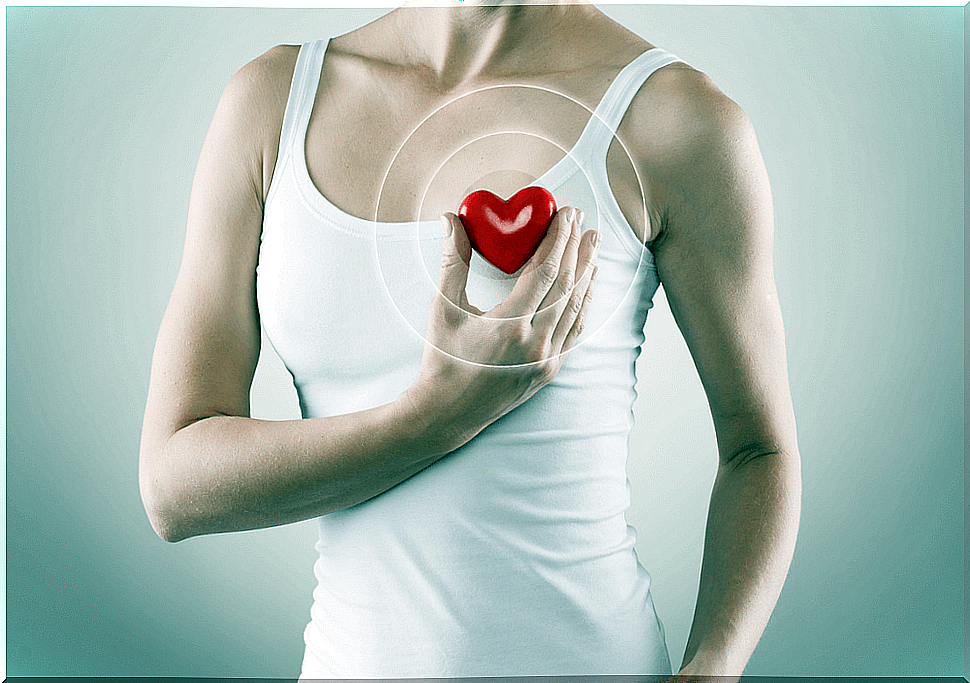 Woman holding a rubber heart, indicating health.