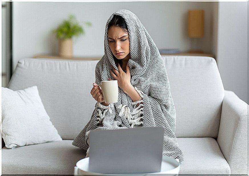 Woman wrapped in a blanket from cold.